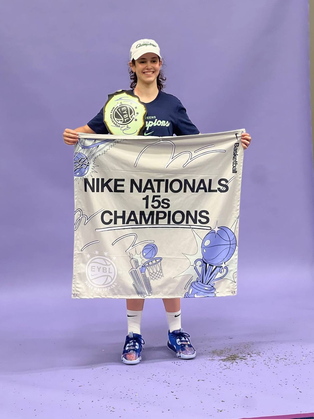 A Farm athlete holding a Nike Nationals champions banner